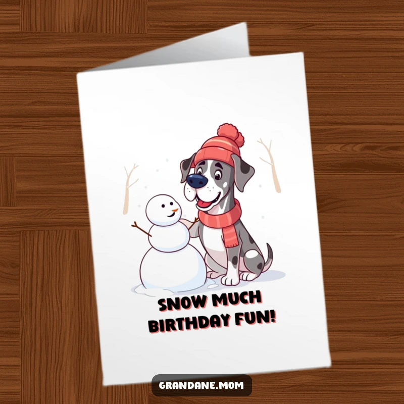 Funny Free Printable Birthday Card: A Great Dane in a winter hat gleefully constructs a snowman, capturing pure birthday joy.